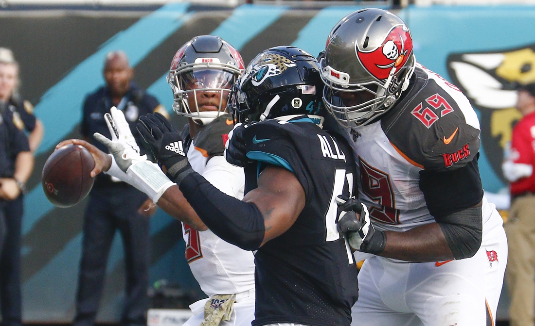 Dec 1, 2019; Jacksonville, FL, USA;  Tampa Bay Buccaneers offensive tackle Demar Dotson (69) blocks Jacksonville Jaguars defensive end Josh Allen (41) as Buccaneers quarterback Jameis Winston (left) throws a pass during the second half at TIAA Bank Field. Mandatory Credit: Reinhold Matay-USA TODAY Sports