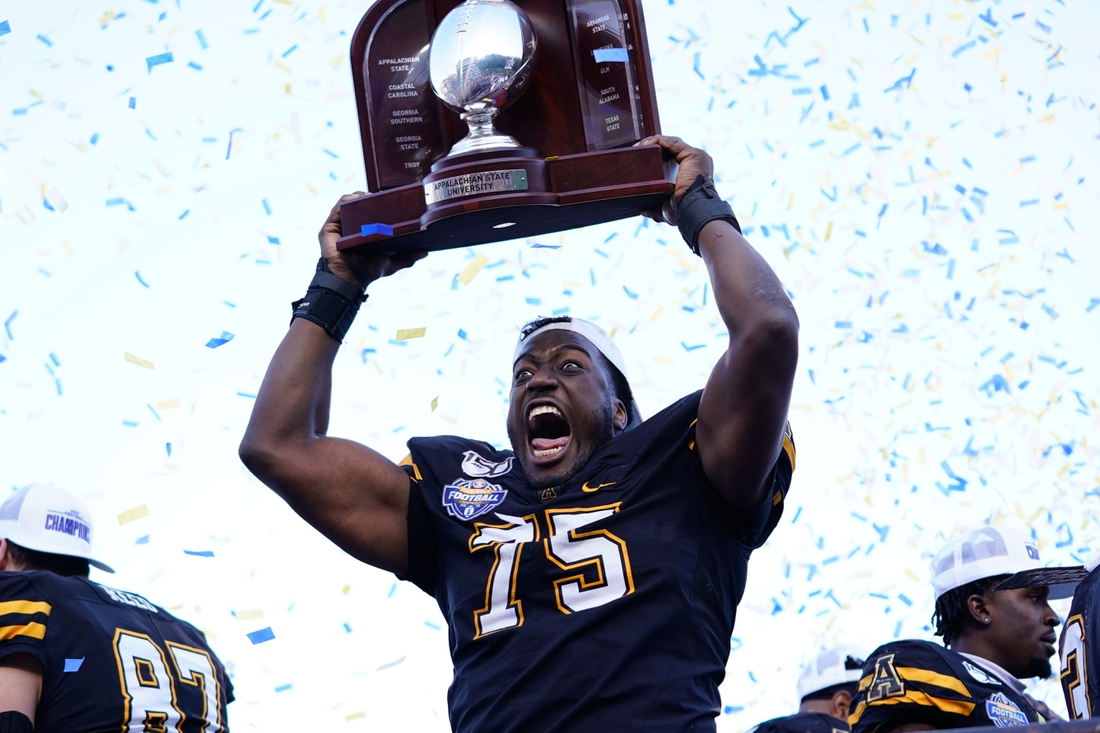 Dec 7, 2019; Boone, NC, USA; Appalachian State Mountaineers offensive lineman Victor Johnson (75) holds up the trophy after defeating the Louisiana-Lafayette Ragin Cajuns at Kidd Brewer Stadium. Mandatory Credit: Jeremy Brevard-USA TODAY Sports