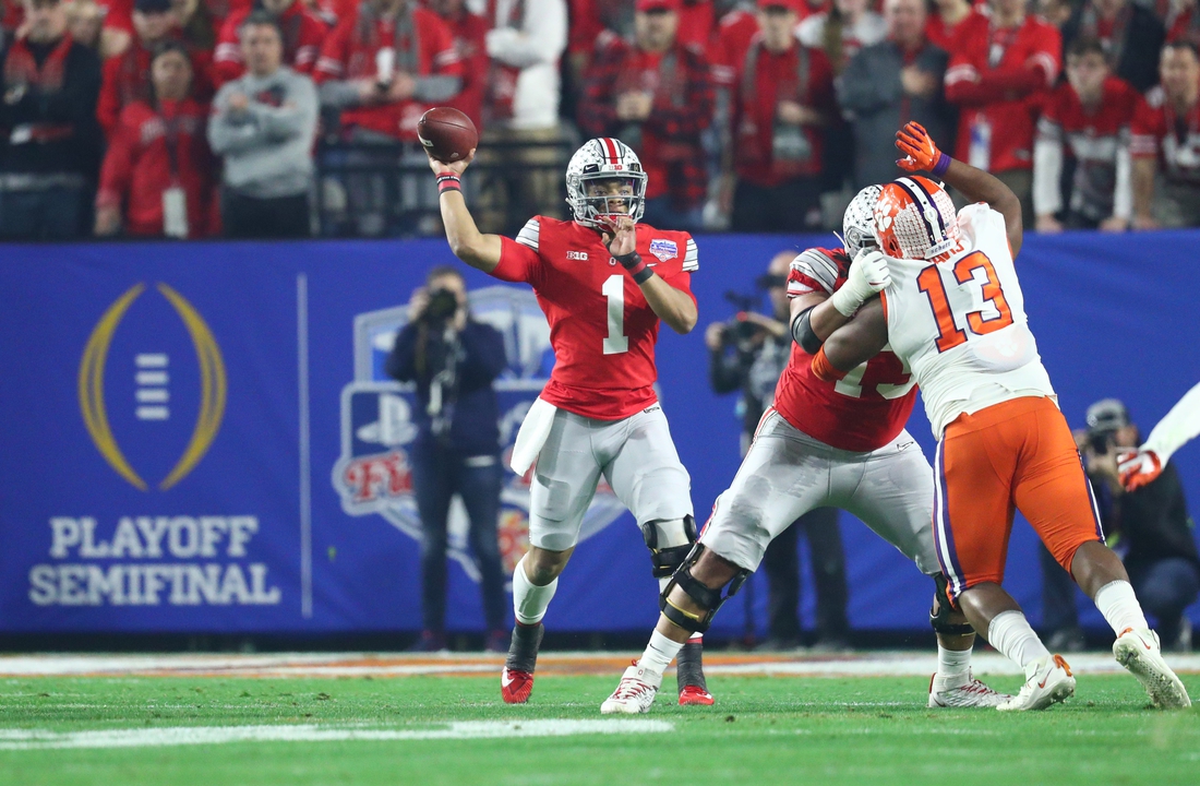 Dec 28, 2019; Glendale, AZ, USA; Ohio State Buckeyes quarterback Justin Fields (1) throws a pass against Clemson Tigers defensive tackle Tyler Davis (13) during the first quarter in the 2019 Fiesta Bowl college football playoff semifinal game at State Farm Stadium. Mandatory Credit: Mark J. Rebilas-USA TODAY Sports