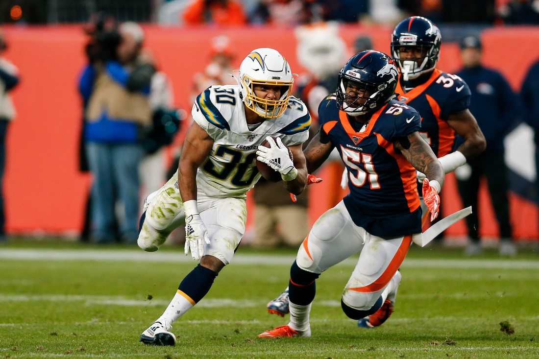 Dec 1, 2019; Denver, CO, USA; Los Angeles Chargers running back Austin Ekeler (30) runs the ball ahead of Denver Broncos inside linebacker Todd Davis (51) in the third quarter at Empower Field at Mile High. Mandatory Credit: Isaiah J. Downing-USA TODAY Sports