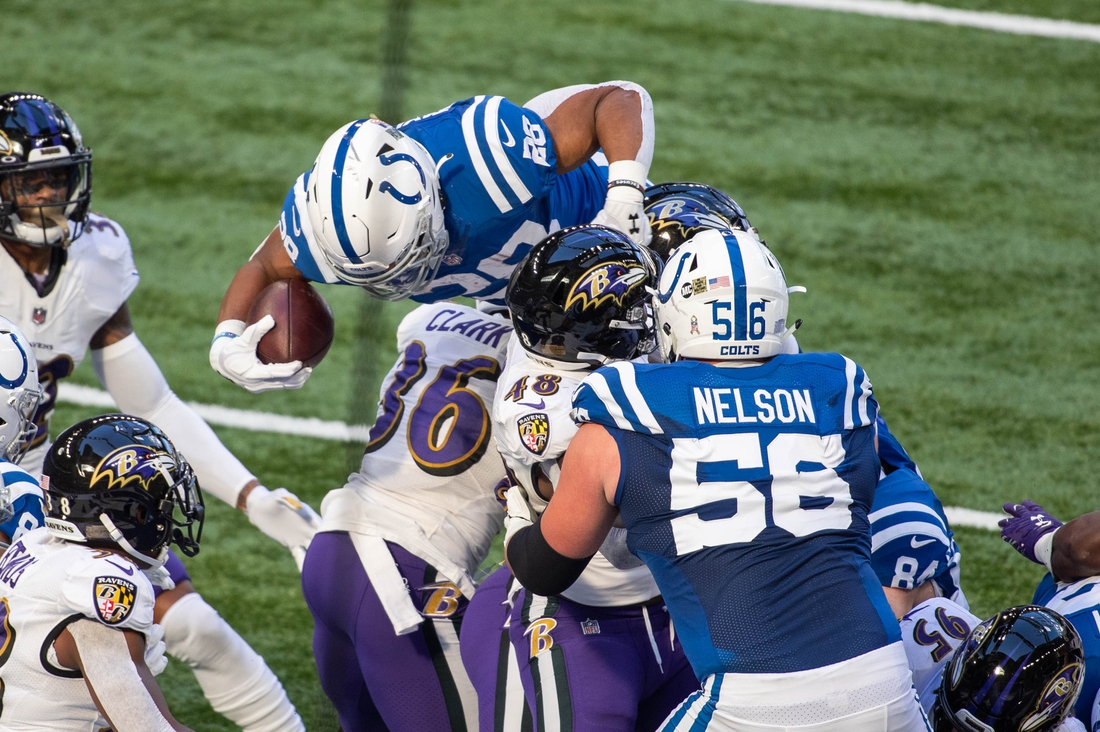 Nov 8, 2020; Indianapolis, Indiana, USA; Indianapolis Colts running back Jonathan Taylor (28) jumps over the Baltimore Ravens defensive line for a touchdown in the first half at Lucas Oil Stadium. Mandatory Credit: Trevor Ruszkowski-USA TODAY Sports