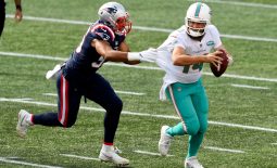 Sep 13, 2020; Foxborough, Massachusetts, USA; Miami Dolphins quarterback Ryan Fitzpatrick (14) runs under pressure from New England Patriots defensive end Derek Rivers (95) during the second half at Gillette Stadium. Mandatory Credit: Brian Fluharty-USA TODAY Sports