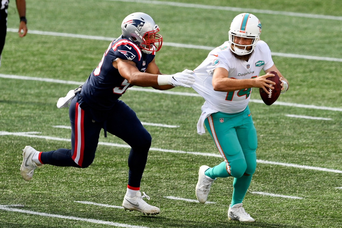 Sep 13, 2020; Foxborough, Massachusetts, USA; Miami Dolphins quarterback Ryan Fitzpatrick (14) runs under pressure from New England Patriots defensive end Derek Rivers (95) during the second half at Gillette Stadium. Mandatory Credit: Brian Fluharty-USA TODAY Sports