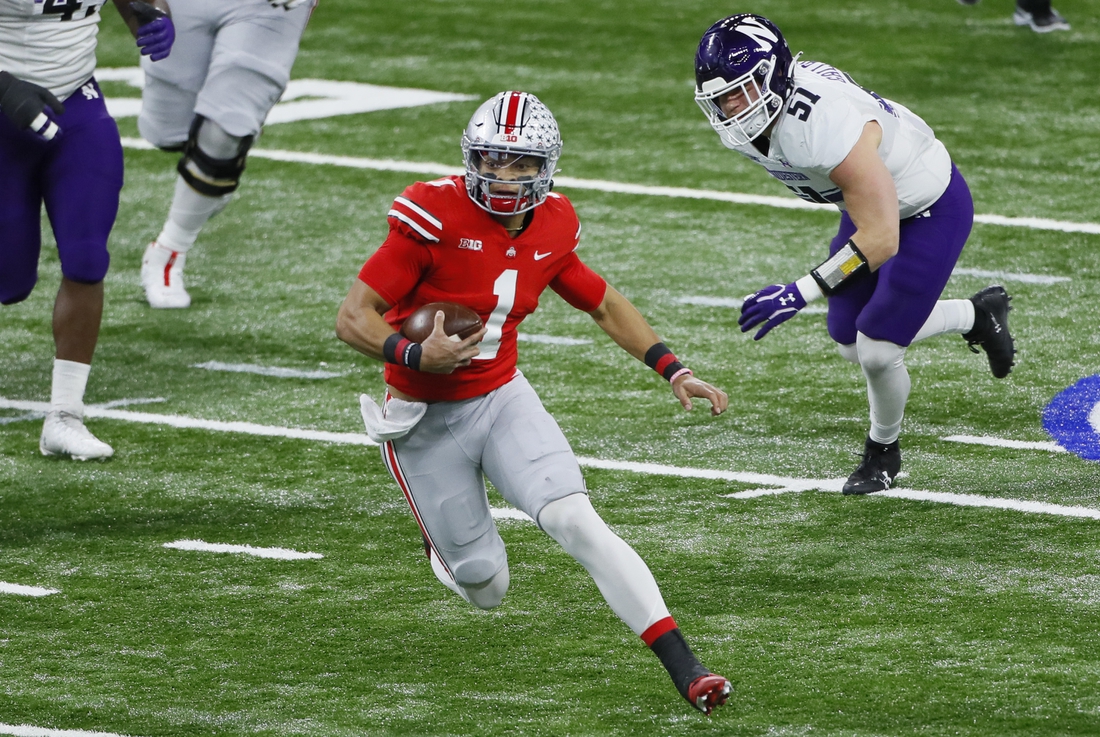 Dec 19, 2020; Indianapolis, IN, USA;  Ohio State Buckeyes quarterback Justin Fields (1) rushes up field ahead of Northwestern Wildcats linebacker Blake Gallagher (51) during the first quarter of the Big Ten Championship football game at Lucas Oil Stadium in Indianapolis on Saturday, Dec. 19, 2020.  Mandatory Credit: Adam Cairns-USA TODAY NETWORK