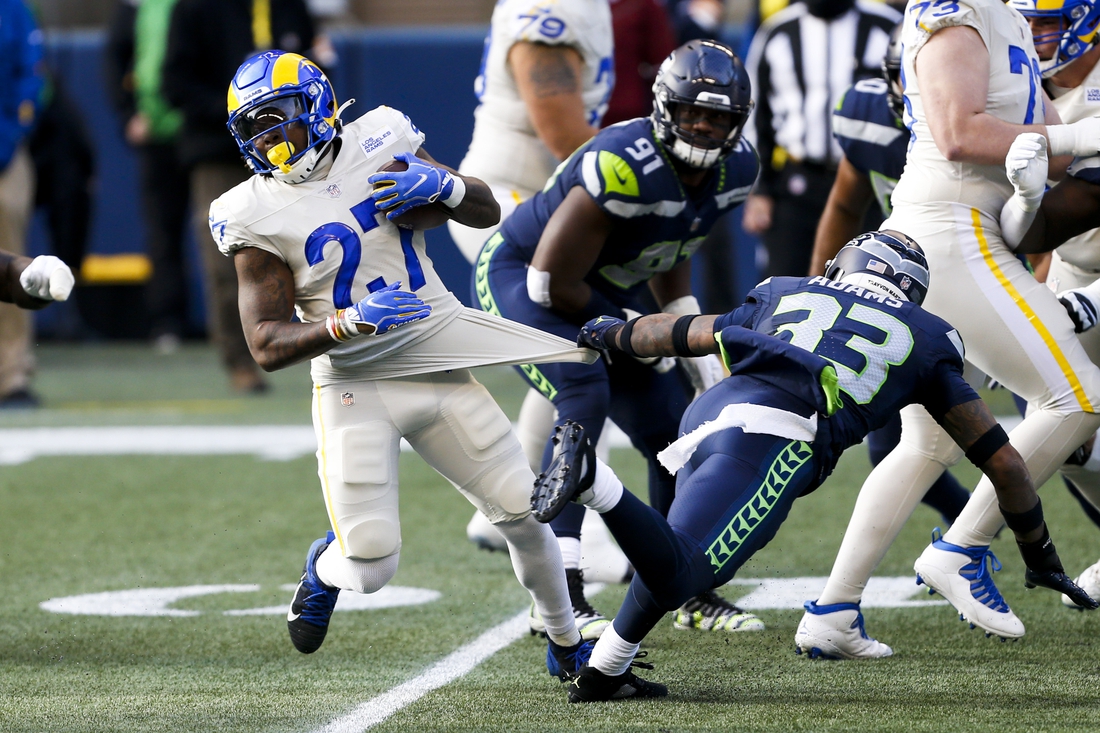 Dec 27, 2020; Seattle, Washington, USA; Los Angeles Rams running back Darrell Henderson (27) rushes against Seattle Seahawks strong safety Jamal Adams (33) during the first quarter at Lumen Field. Mandatory Credit: Joe Nicholson-USA TODAY Sports