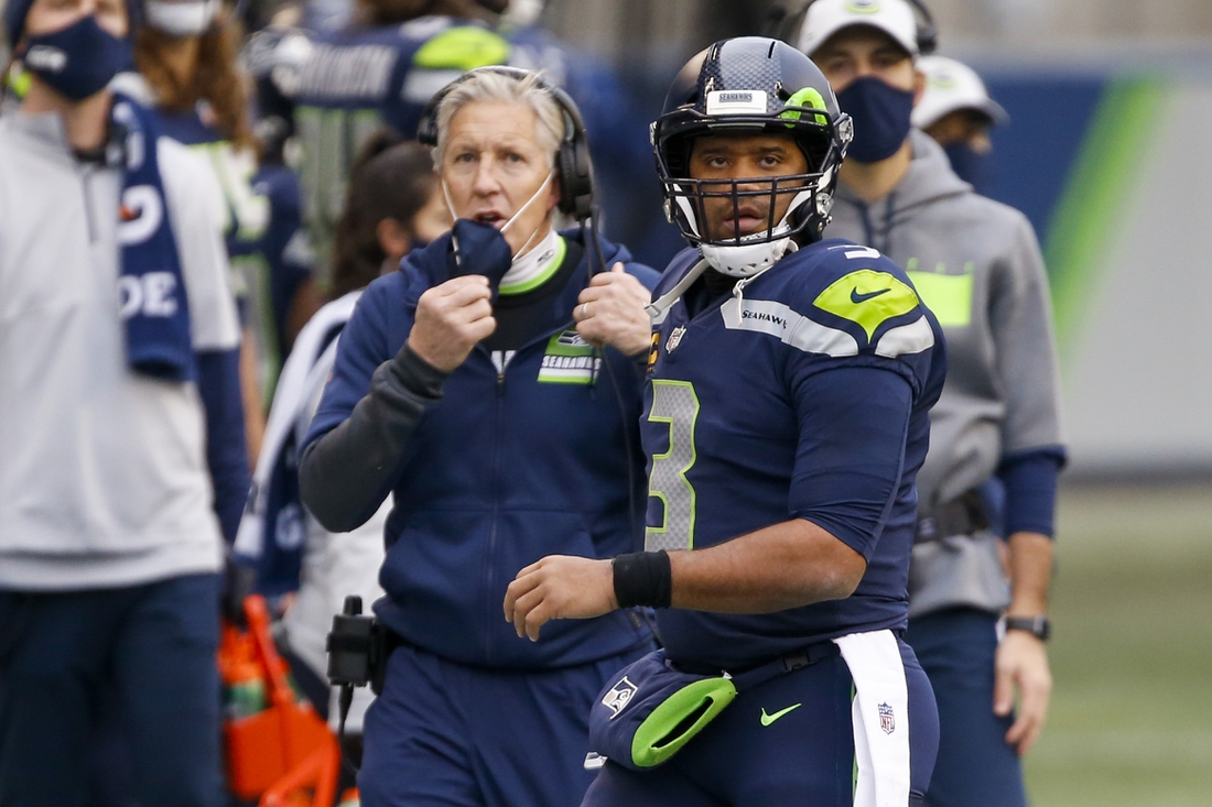 Dec 6, 2020; Seattle, Washington, USA; Seattle Seahawks quarterback Russell Wilson (3) walks back to the sideline following a failed third down play against the New York Giants during the second quarter at Lumen Field. Seattle Seahawks head coach Pete Carroll stands behind Wilson. Mandatory Credit: Joe Nicholson-USA TODAY Sports