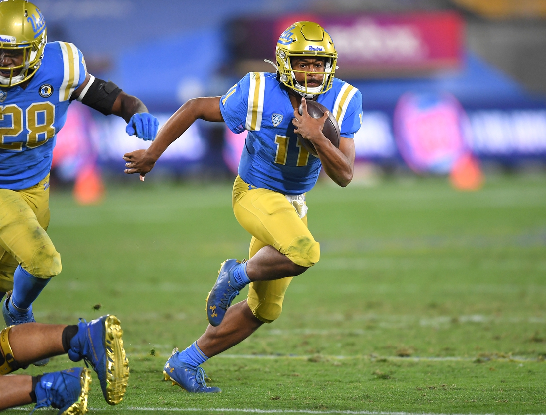 Dec 19, 2020; Pasadena, California, USA; UCLA Bruins quarterback Chase Griffin (11) runs the ball during overtime against the Stanford Cardinal at the Rose Bowl. Mandatory Credit: Jayne Kamin-Oncea-USA TODAY Sports