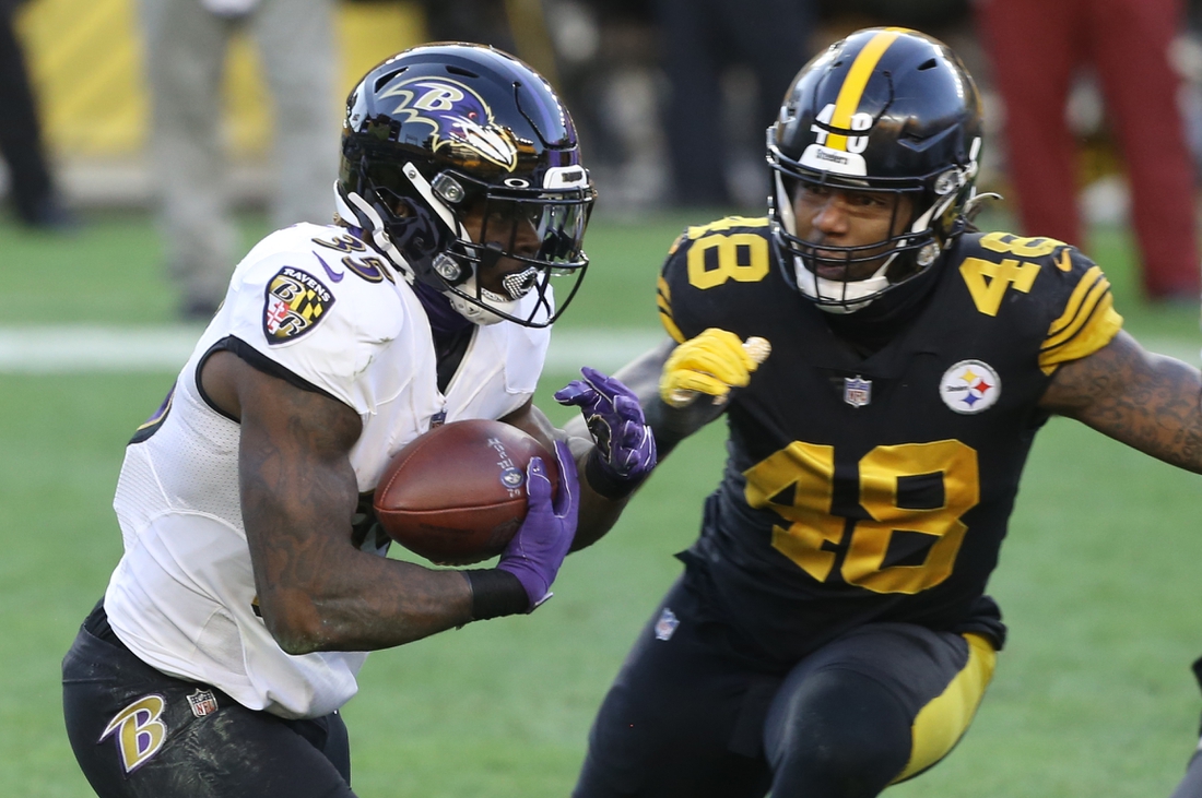 Dec 2, 2020; Pittsburgh, Pennsylvania, USA;  Baltimore Ravens running back Gus Edwards (35) carries the ball against Pittsburgh Steelers outside linebacker Bud Dupree (48) during the first quarter at Heinz Field. Mandatory Credit: Charles LeClaire-USA TODAY Sports