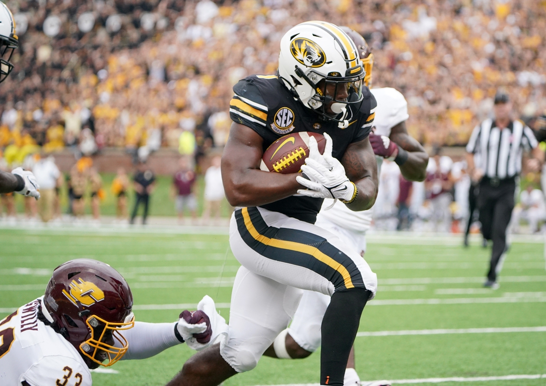 Sep 4, 2021; Columbia, Missouri, USA; Missouri Tigers running back Tyler Badie (1) scores a touchdown as Central Michigan Chippewas linebacker Nick Apsey (32) attempts the tackle during the first half at Faurot Field at Memorial Stadium. Mandatory Credit: Denny Medley-USA TODAY Sports