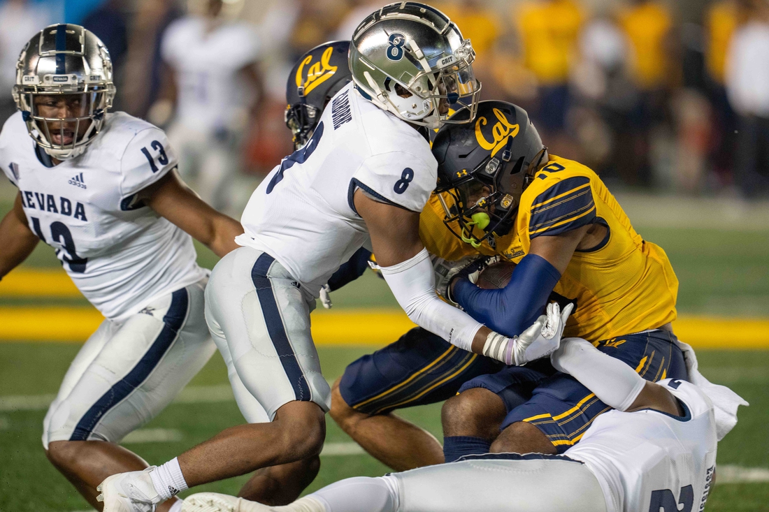 Sep 4, 2021; Berkeley, California, USA; California Golden Bears wide receiver Jeremiah Hunter (10) is tackled by Nevada Wolf Pack cornerback Isaiah Essissima (2) and defensive back JoJuan Claiborne (8) during the second quarter at FTX Field at California Memorial Stadium. Mandatory Credit: Neville E. Guard-USA TODAY Sports
