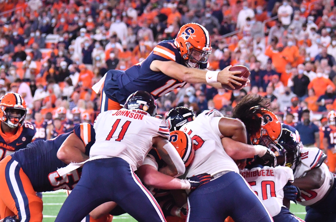 Sep 24, 2021; Syracuse, New York, USA; Syracuse Orange quarterback Garrett Shrader (16) leaps over the line of scrimmage to score a touchdown against the Liberty Flames in the second quarter at the Carrier Dome. Mandatory Credit: Mark Konezny-USA TODAY Sports