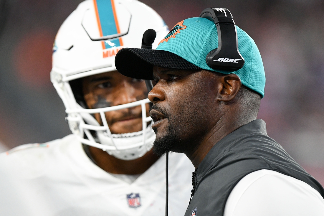 Sep 12, 2021; Foxborough, Massachusetts, USA; Miami Dolphins head coach Brian Flores talks with quarterback Tua Tagovailoa (1) during a timeout during the second half of a game against the New England Patriots at Gillette Stadium. Mandatory Credit: Brian Fluharty-USA TODAY Sports