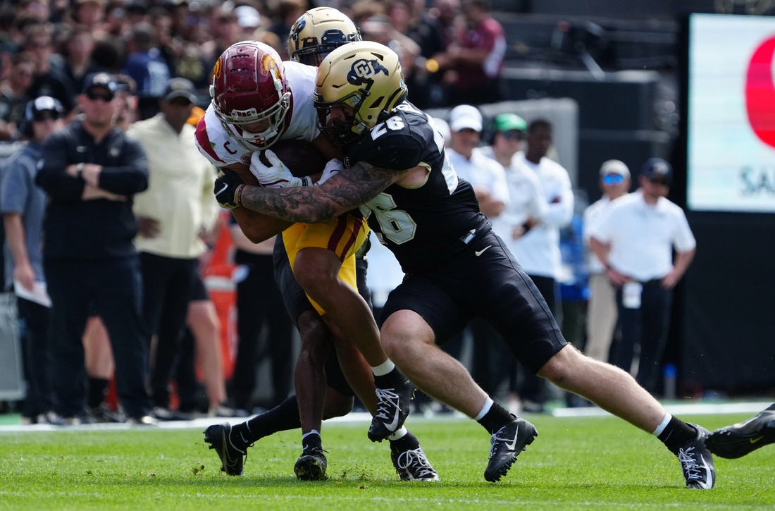 Oct 2, 2021; Boulder, Colorado, USA; Colorado Buffaloes linebacker Carson Wells (26) tackles USC Trojans wide receiver Drake London (15) in the second quarter at Folsom Field. Mandatory Credit: Ron Chenoy-USA TODAY Sports