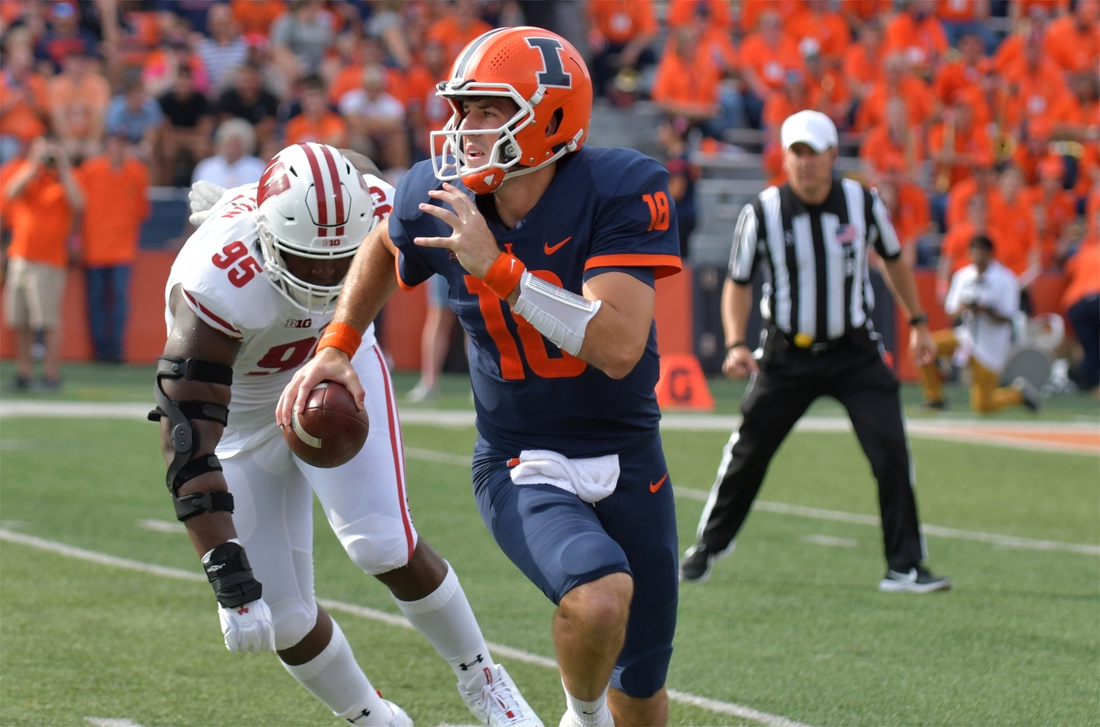 Oct 9, 2021; Champaign, Illinois, USA; Illinois Fighting Illini quarterback Brandon Peters (18) runs with the ball as Wisconsin Badgers defensive tackle Keeanu Benton (95) pursues in the first half at Memorial Stadium. Mandatory Credit: Ron Johnson-USA TODAY Sports