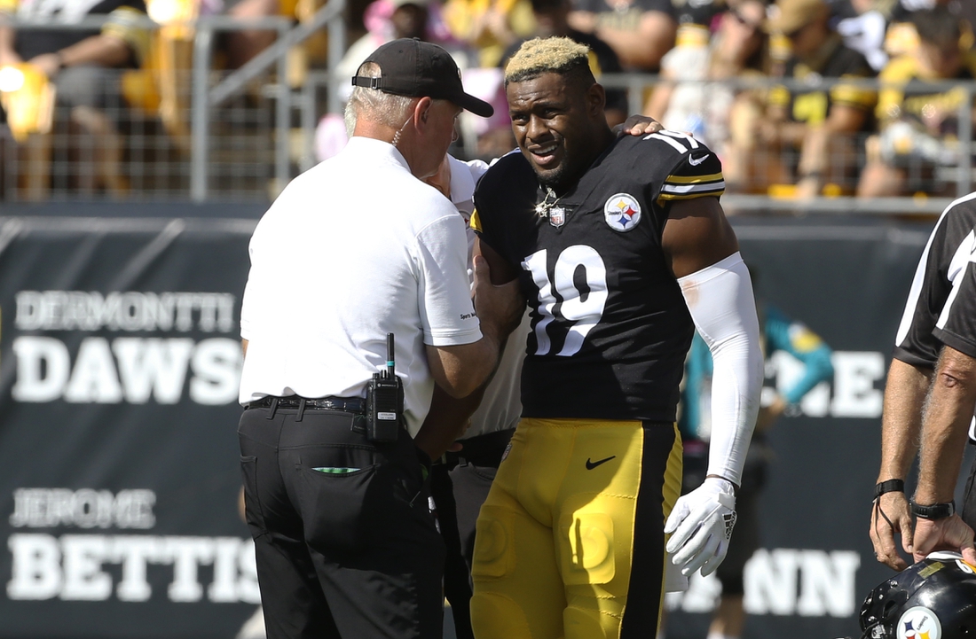 Oct 10, 2021; Pittsburgh, Pennsylvania, USA;  Pittsburgh Steelers team orthopedic doctor James Bradley (left) looks at the right arm of Pittsburgh Steelers wide receiver JuJu Smith-Schuster (19) after Smith-Schuster suffered an apparent injury against the Denver Broncos during the second quarter at Heinz Field. Smith-Schuster  would leave the game. Mandatory Credit: Charles LeClaire-USA TODAY Sports
