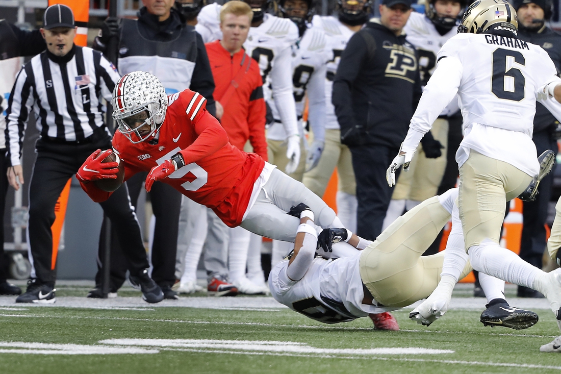 Nov 13, 2021; Columbus, Ohio, USA; Ohio State Buckeyes wide receiver Garrett Wilson (5) dives for the first down as he is tackled by Purdue Boilermakers safety Cam Allen (10) during the first quarter at Ohio Stadium. Mandatory Credit: Joseph Maiorana-USA TODAY Sports