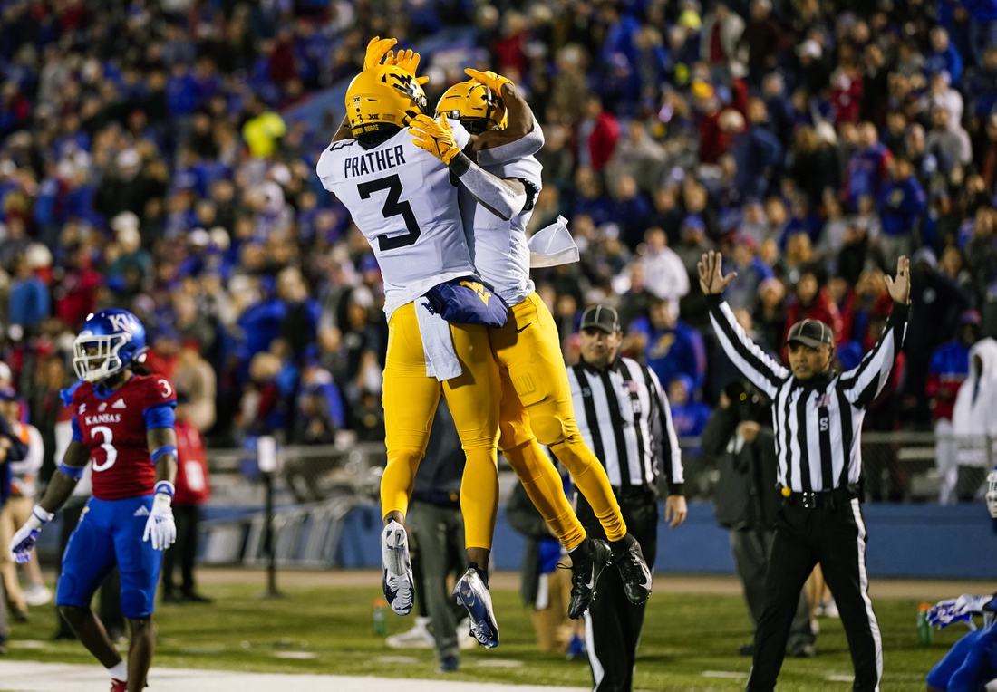 Nov 27, 2021; Lawrence, Kansas, USA; West Virginia Mountaineers wide receiver Winston Wright Jr. (1) celebrates with wide receiver Kaden Prather (3) after scoring a touchdown against the Kansas Jayhawks during the first half at David Booth Kansas Memorial Stadium. Mandatory Credit: Jay Biggerstaff-USA TODAY Sports