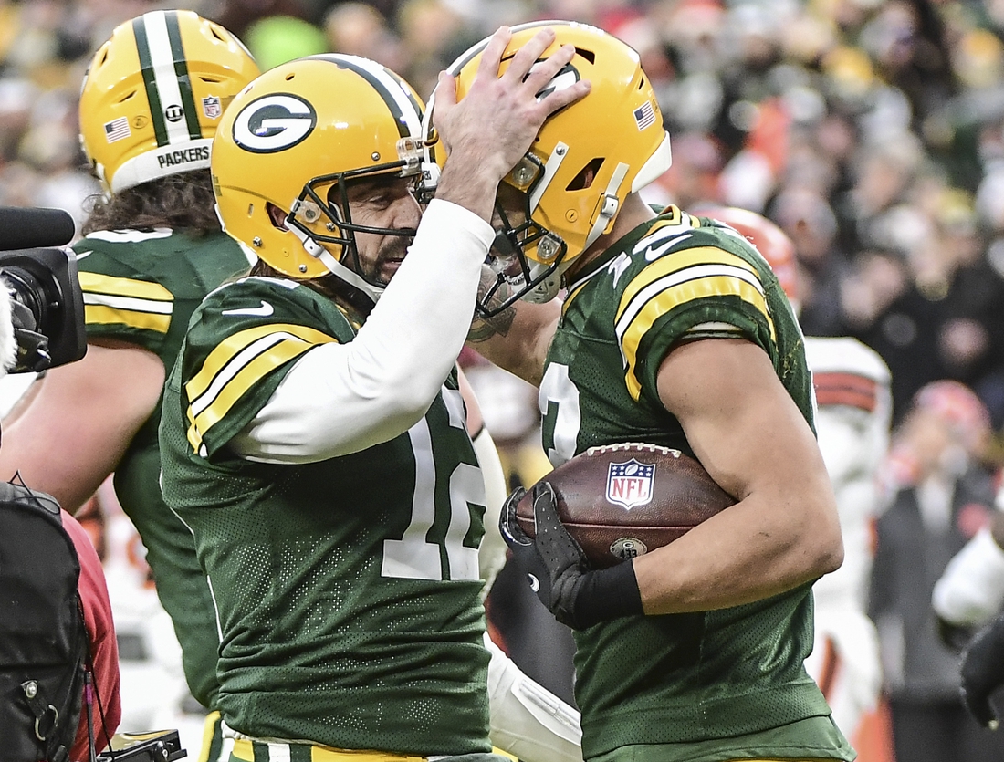 Dec 25, 2021; Green Bay, Wisconsin, USA; Green Bay Packers quarterback Aaron Rodgers (12) celebrates with wide receiver Allen Lazard (13) after setting the franchise record for most passing TDs in the first quarter during the game against the Cleveland Browns at Lambeau Field. Mandatory Credit: Benny Sieu-USA TODAY Sports