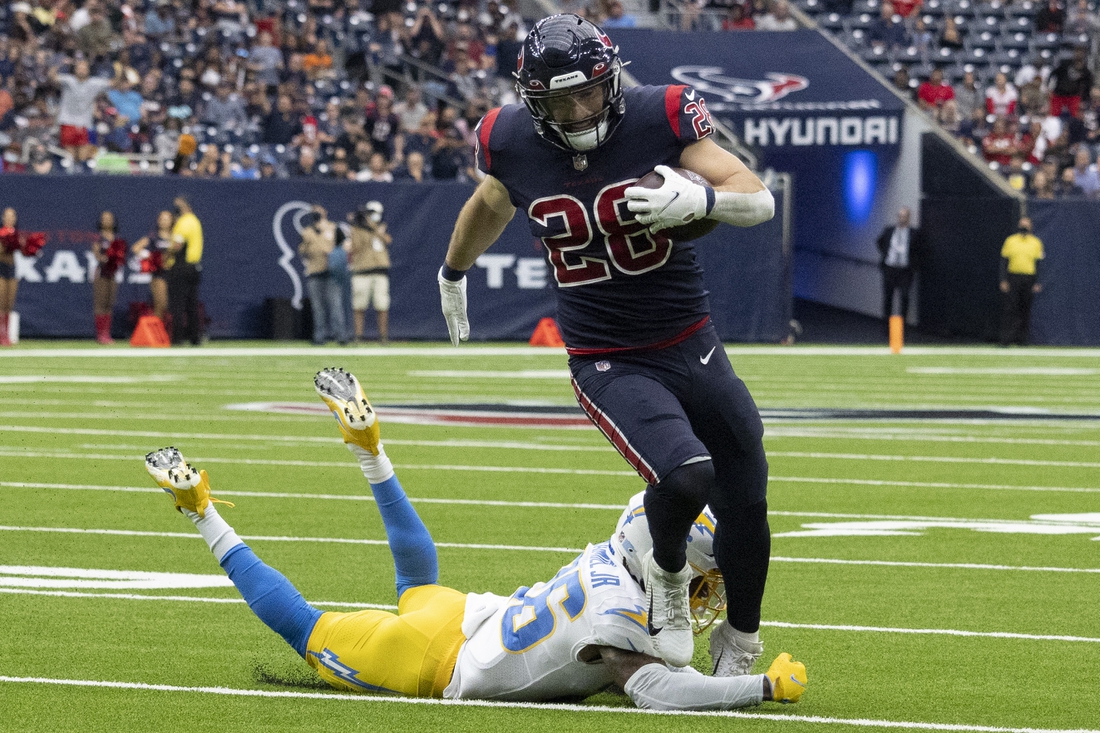 Dec 26, 2021; Houston, Texas, USA;  Houston Texans running back Rex Burkhead (28) runs for a touchdown against Los Angeles Chargers defensive back Trey Marshall (36) in the first quarter at NRG Stadium. Mandatory Credit: Thomas Shea-USA TODAY Sports