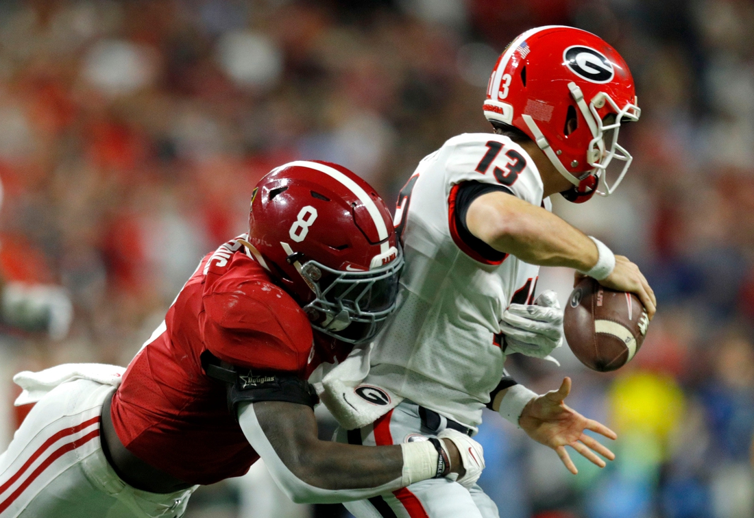 Alabama Crimson Tide linebacker Christian Harris (8) causes Georgia Bulldogs quarterback Stetson Bennett (13) to fumble and turn over the ball Monday, Jan. 10, 2022, during the College Football Playoff National Championship at Lucas Oil Stadium in Indianapolis.