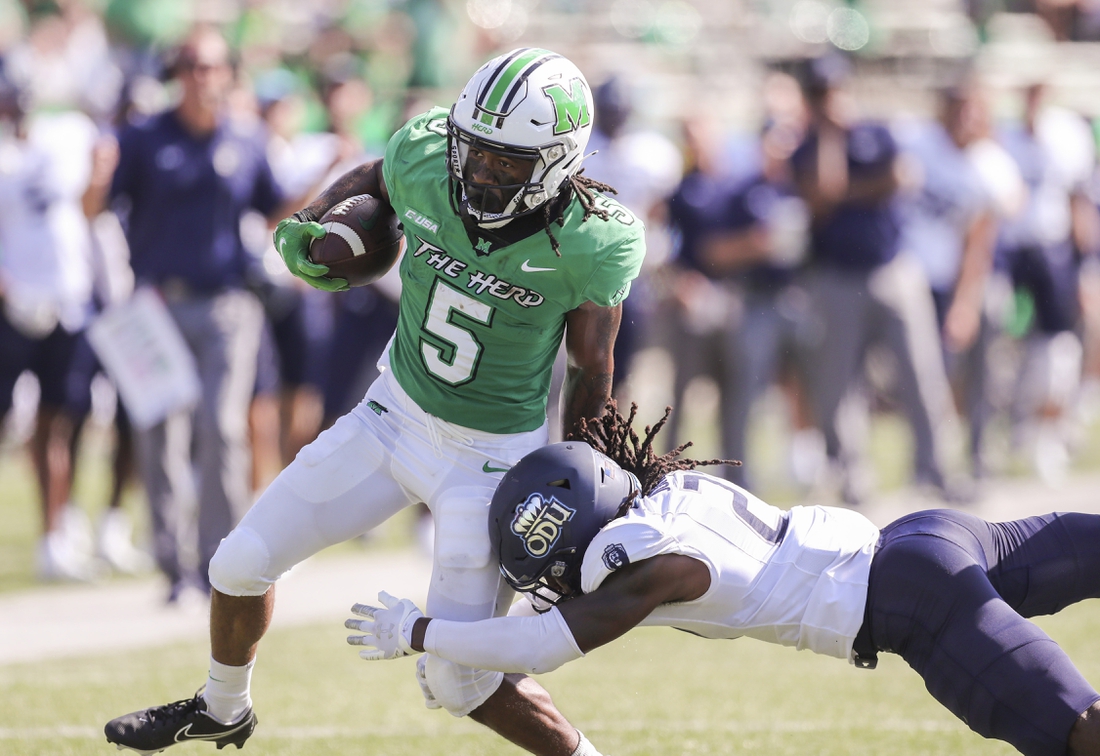 Oct 9, 2021; Huntington, West Virginia, USA; Marshall Thundering Herd running back Sheldon Evans (5) runs the ball and shakes a tackle from Old Dominion Monarchs safety R'Tarriun Johnson (21) during the second quarter at Joan C. Edwards Stadium. Mandatory Credit: Ben Queen-USA TODAY Sports