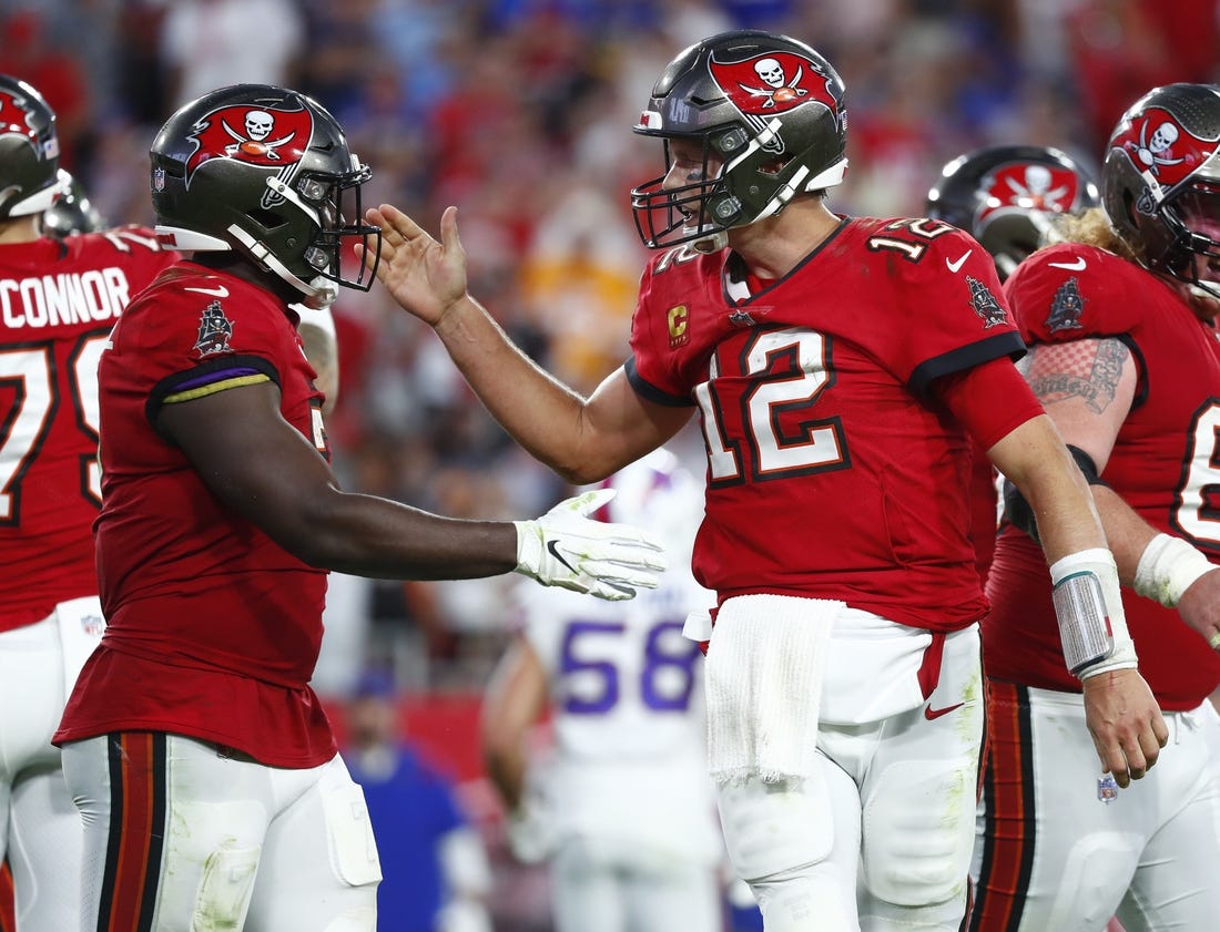 Dec 12, 2021; Tampa, Florida, USA; Tampa Bay Buccaneers quarterback Tom Brady (12) celebrates with  running back Leonard Fournette (7) after running the ball in for a touchdown against the Buffalo Bills during the first half at Raymond James Stadium. Mandatory Credit: Kim Klement-USA TODAY Sports