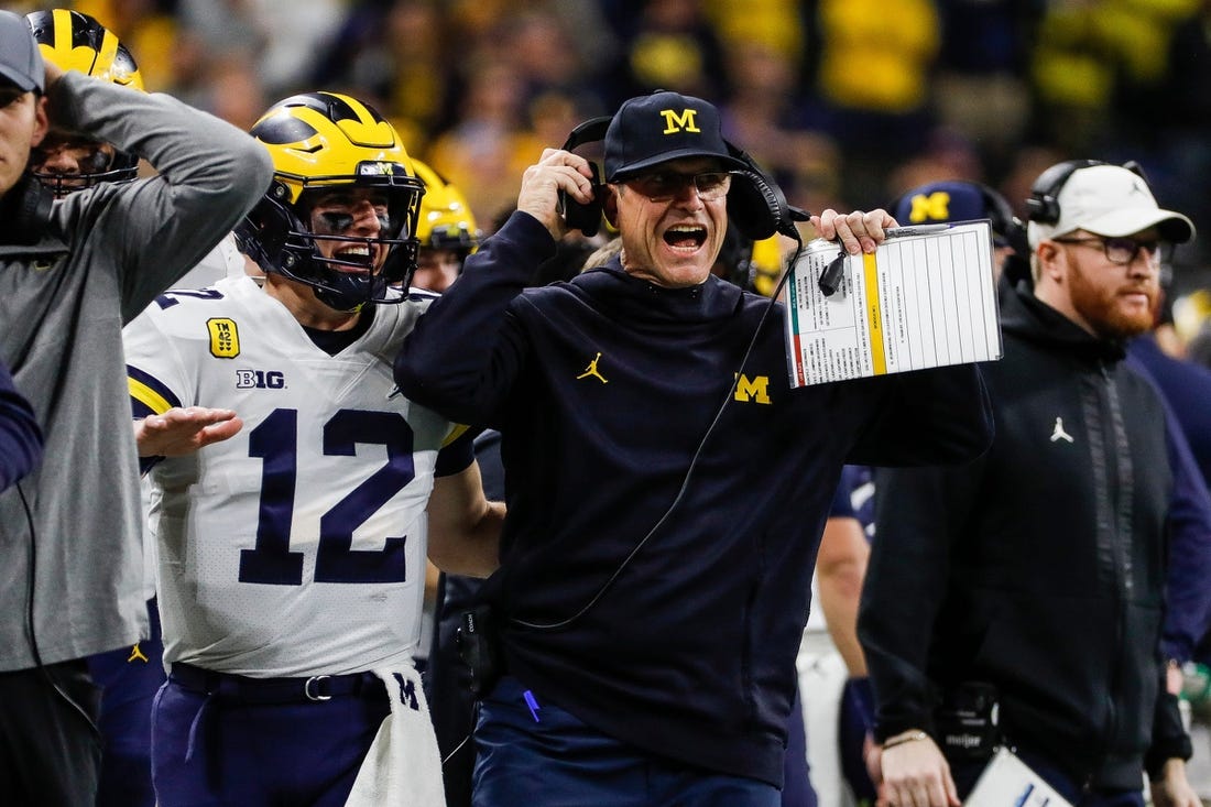 Michigan coach Jim Harbaugh and quarterback Cade McNamara celebrate a touchdown against Iowa during the first half of the Big Ten championship game at Lucas Oil Stadium in Indianapolis on Saturday, Dec. 4, 2021.

Syndication Detroit Free Press