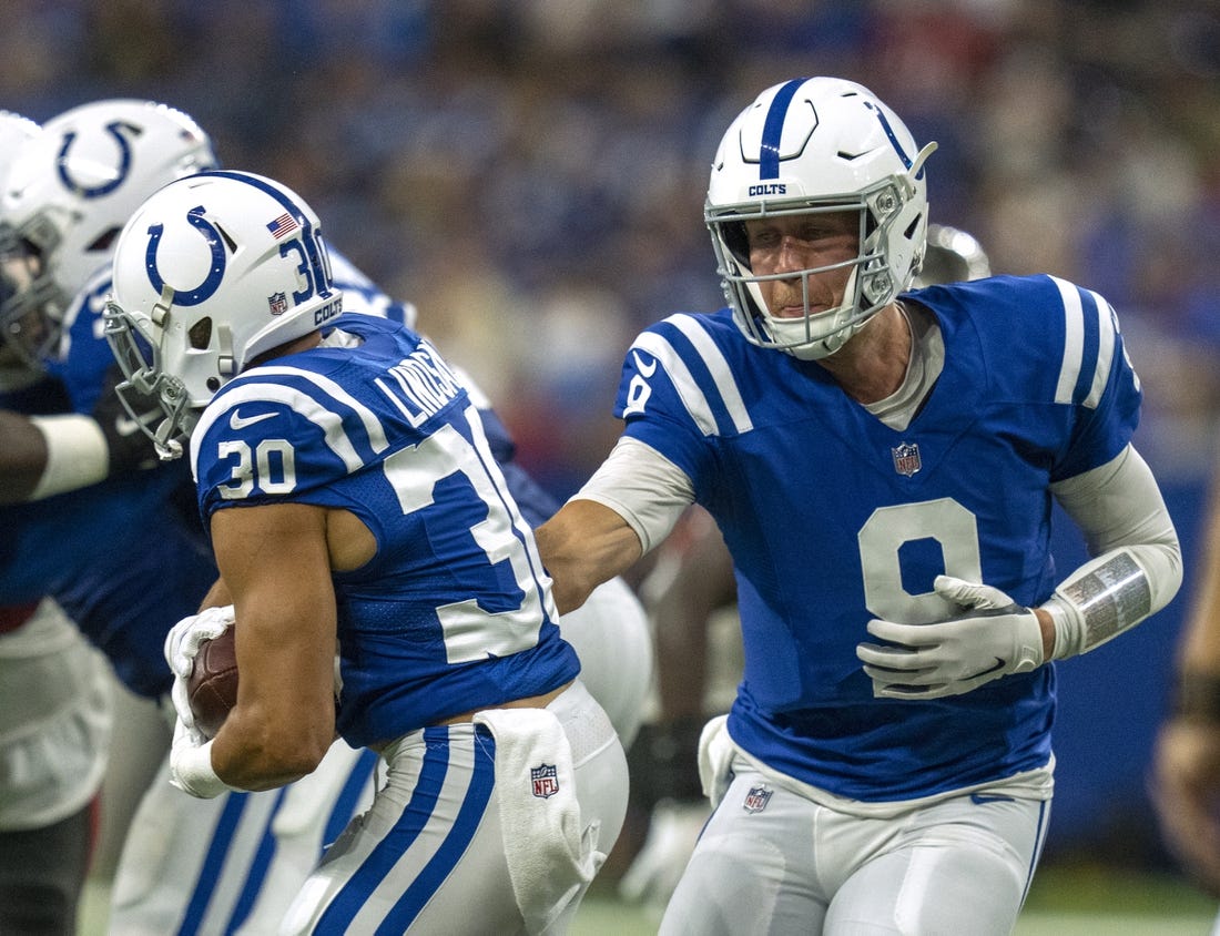 Aug 27, 2022; Indianapolis, Indiana, USA; Indianapolis Colts quarterback Nick Foles (9) hands off to running back Phillip Lindsay (30) against the Tampa Bay Buccaneers during a preseason game at Lucas Oil Stadium. Mandatory Credit: Robert Scheer-USA TODAY Sports