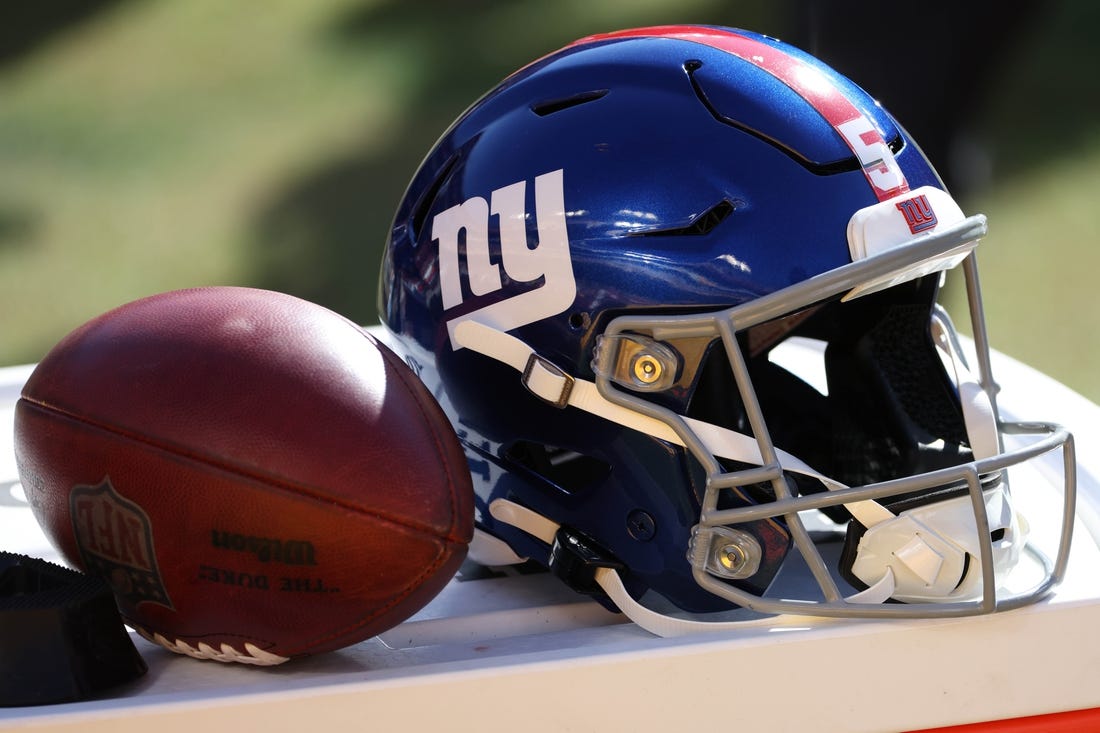 Nov 8, 2020; Landover, Maryland, USA; A view of the helmet of New York Giants kicker Graham Gano (not pictured) next to a ball on the sidelines against the Washington Football Team at FedExField. Mandatory Credit: Geoff Burke-USA TODAY Sports