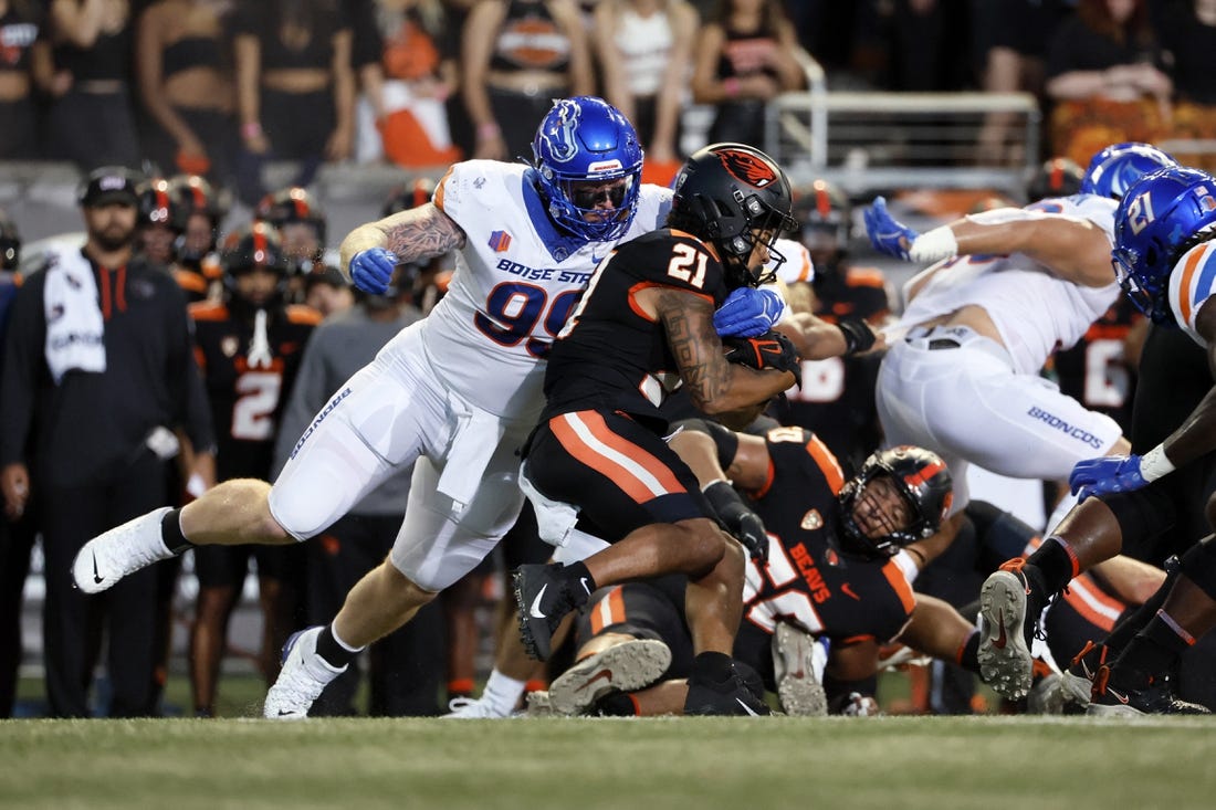 Sep 3, 2022; Corvallis, Oregon, USA; Oregon State Beavers running back Trey Lowe (21) is grabbed by Boise State Broncos defensive tackle Scott Matlock (99) during the first half at Reser Stadium. Mandatory Credit: Soobum Im-USA TODAY Sports