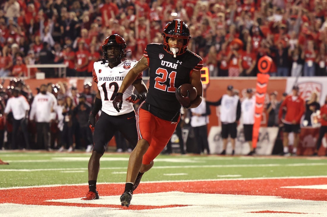 Sep 17, 2022; Salt Lake City, Utah, USA; Utah Utes wide receiver Solomon Enis (21) scores a touchdown against San Diego State Aztecs cornerback Dallas Branch (12) in the second quarter at Rice-Eccles Stadium. Mandatory Credit: Rob Gray-USA TODAY Sports