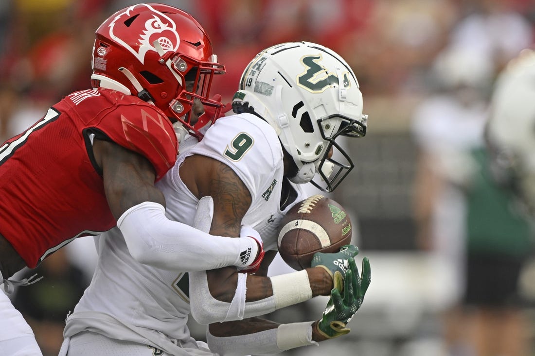 Sep 24, 2022; Louisville, Kentucky, USA;  South Florida Bulls receiver Yusuf Terry (9) catches a pass under the pressure of Louisville Cardinals defensive back Kei'Trel Clark (13) during the second quarter at Cardinal Stadium. Mandatory Credit: Jamie Rhodes-USA TODAY Sports