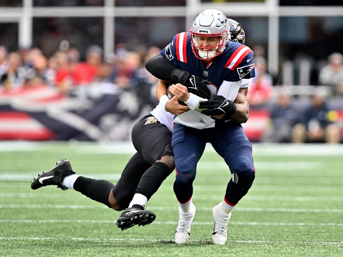 Sep 25, 2022; Foxborough, Massachusetts, USA; New England Patriots quarterback Mac Jones (10) is tackled by Baltimore Ravens linebacker Odafe Oweh (99) during the first half at Gillette Stadium. Mandatory Credit: Brian Fluharty-USA TODAY Sports
