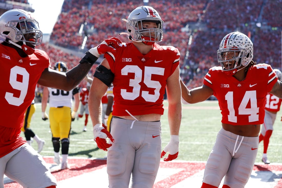 Oct 22, 2022; Columbus, Ohio, USA;  Ohio State Buckeyes linebacker Tommy Eichenberg (35) celebrates his interception return for a touchdown with safety Ronnie Hickman (14) and defensive end Zach Harrison (9) during the second quarter against the Iowa Hawkeyes at Ohio Stadium. Mandatory Credit: Joseph Maiorana-USA TODAY Sports