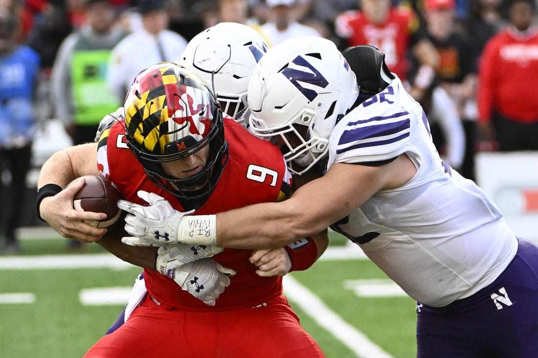 Oct 22, 2022; College Park, Maryland, USA; Northwestern Wildcats linebacker Bryce Gallagher (32) and Northwestern Wildcats defensive back Rod Heard II (24) sack Maryland Terrapins quarterback Billy Edwards Jr. (9) during the first half at SECU Stadium. Mandatory Credit: Brad Mills-USA TODAY Sports
