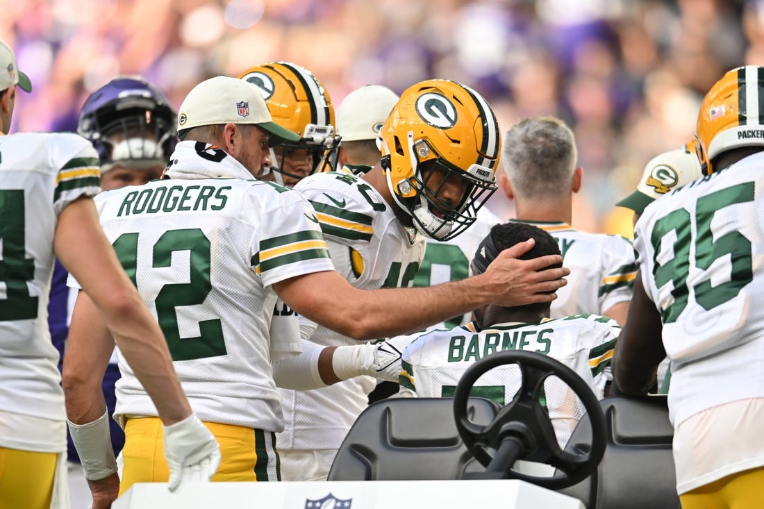 Sep 11, 2022; Minneapolis, Minnesota, USA; Green Bay Packers quarterback Aaron Rodgers (12) and linebacker Tipa Galeai (40) react with linebacker Krys Barnes (51) who was injured against the Minnesota Vikings during the fourth quarter at U.S. Bank Stadium. Mandatory Credit: Jeffrey Becker-USA TODAY Sports
