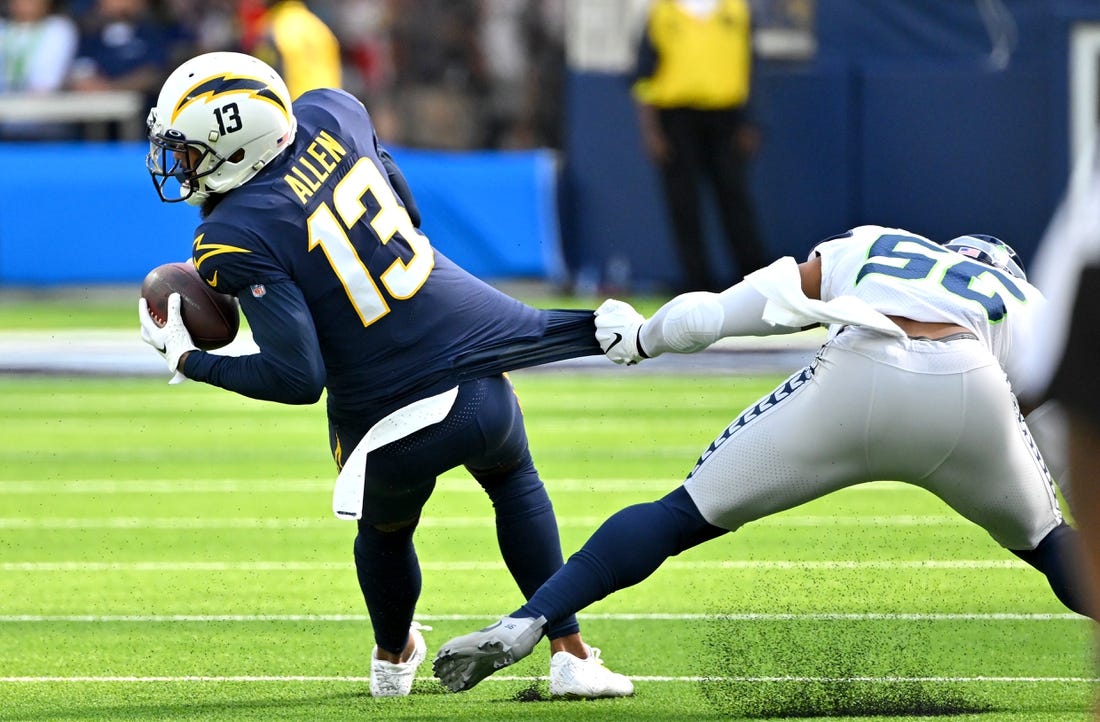 Oct 23, 2022; Inglewood, California, USA;  Los Angeles Chargers wide receiver Keenan Allen (13) runs for a first down before he is stopped by Seattle Seahawks linebacker Jordyn Brooks (56) in the first half at SoFi Stadium. Mandatory Credit: Jayne Kamin-Oncea-USA TODAY Sports