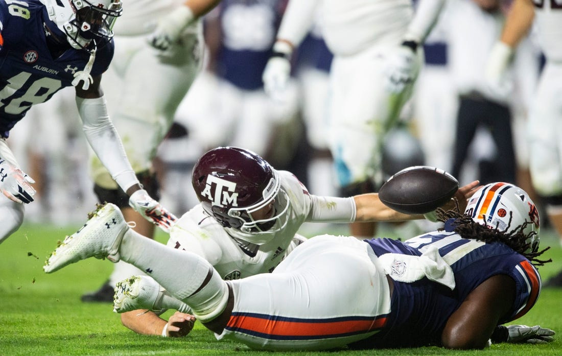 Texas A&M Aggies quarterback Conner Weigman (15) and Auburn Tigers defensive lineman Marcus Harris (50) dive for a fumble recovered by Weigman as Auburn Tigers take on Texas A&M Aggies at Jordan-Hare Stadium in Auburn, Ala., on Saturday, Nov. 12, 2022.
