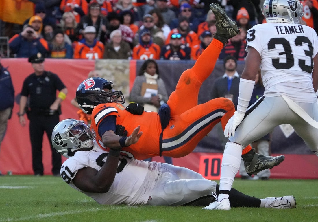 Nov 20, 2022; Denver, Colorado, USA; Las Vegas Raiders defensive tackle Bilal Nichols (91) hits Denver Broncos quarterback Russell Wilson (3) in the second quarter at Empower Field at Mile High. Mandatory Credit: Ron Chenoy-USA TODAY Sports