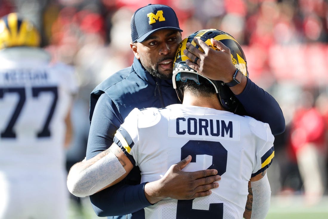 Michigan running back Blake Corum (2) is hugged by co-offensive coordinator Sherrone Moore during warmups before the game Nov. 26, 2022 against Ohio State at Ohio Stadium in Columbus.