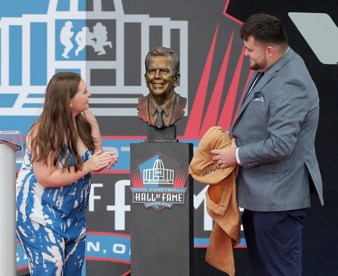 Shannon and Connor O'Hara, the grandchildren of Art McNally's admire their grandfather's bust during the Pro Football Hall of Fame Enshrinement at Tom Benson Stadium in Canton on Saturday, August 6, 2022.

Art Mcnally 0035